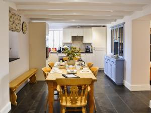 a kitchen with a wooden table and chairs at Prideaux Farmhouse in Luxulyan