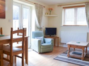 a living room with a chair and a table at The Hayloft - 28836 in Royal Wootton Bassett
