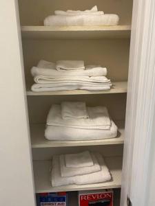 un armario con toallas blancas y un montón de toallas en Cozy 4 bedroom Home Welcomes You en Bear