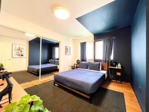 ein Schlafzimmer mit einem Bett und einer blauen Wand in der Unterkunft Diamond in LA - AM3-CUL in Los Angeles