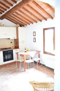 a kitchen and dining room with a table and chairs at Apartment with Little Arch in Montepulciano