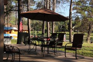 une table et des chaises sous un parasol sur une terrasse dans l'établissement Mt. Bachelor & Sun River Get Away, à Bend