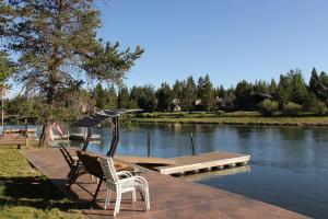 a couple of chairs and an umbrella next to a river at Mt. Bachelor & Sun River Get Away in Bend