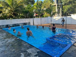 un grupo de personas en una piscina en White Elephant Villa & Restaurant, en Beruwala