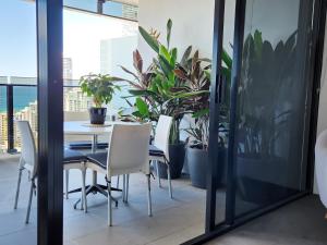 a dining room with plants and a table and chairs at Sealuxe - Surfers Paradise Central -- Ocean View Deluxe Residences in Gold Coast