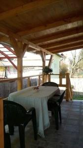 a patio with a table and chairs on a porch at Cseresznyés Vendégház in Mezőkövesd