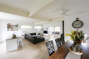 a living room with a couch and a clock on the wall at Pandora Beach House in Venus Bay