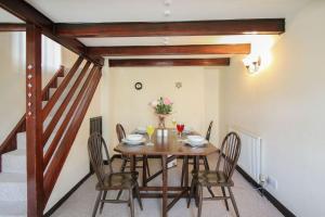 a dining room with a wooden table and chairs at Sunny Corner Cottage in Hayle
