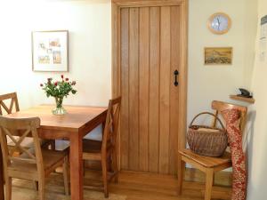 a dining room with a table and a wooden door at Cribba in Wadebridge