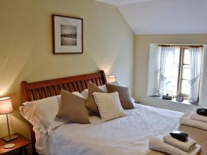 a bedroom with a bed with white sheets and pillows at Cribba in Wadebridge