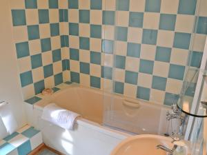 a bathroom with a tub and a toilet and a sink at Cribba in Wadebridge