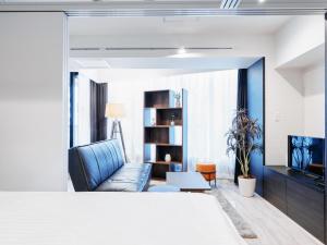 Sukumo -蒅- في طوكيو: غرفة معيشة مع أريكة زرقاء وتلفزيون