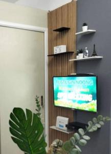 a living room with a television and a plant at Chic 2BR Condo Unit at South Residences in Manila