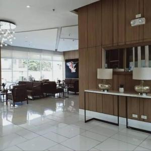 a lobby with tables and chairs in a building at Chic 2BR Condo Unit at South Residences in Manila +7 photos