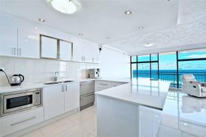 a white kitchen with a view of the ocean at Surfers Paradise Apartment With Amazing Views in Gold Coast