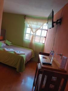 a room with two beds and a table and a window at Hotel California in Mineral del Monte