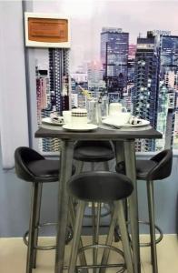 a table with four chairs and a view of a city at Chic 2BR Condo Unit at South Residences in Manila
