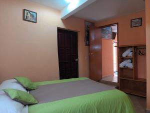 a bedroom with a large bed with green sheets at Hotel California in Mineral del Monte