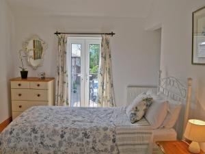 a bedroom with a bed and a dresser and a window at Brown Dyke Stables in Kirklinton