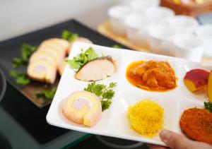 a white plate with food on a table at APA Hotel TKP Keikyu Kawasaki Ekimae in Kawasaki