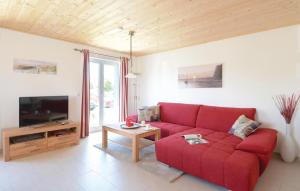 ein Wohnzimmer mit einem roten Sofa und einem TV in der Unterkunft Ferienhaus 6 Altefhr in Altefähr