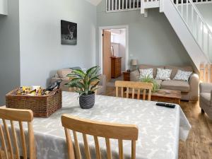 a living room with a table and chairs and a couch at Galloway Farmstay - Claunch in Kirkinner