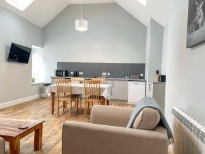 a living room with a couch and a table with chairs at Galloway Farmstay - Claunch in Kirkinner