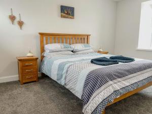a bedroom with a large bed with a wooden headboard at Galloway Farmstay - Claunch in Kirkinner