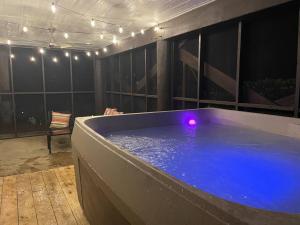 微风湾Woodsy Retreat, steps to Bay - Hot tub!的客房内的紫色光大热水浴池