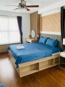 - une chambre avec un lit doté de draps bleus et d'un ventilateur dans l'établissement Three-bedroom house with sea view, à Hạ Long