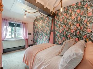 a bedroom with a bed with a floral wallpaper at The Tipsy Bee At 143, in Guisborough