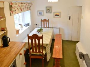 uma pequena cozinha com mesa e cadeiras num quarto em Junipers - 28180 em Puncknowle