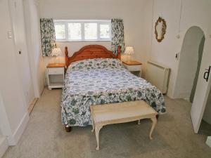 um quarto com uma cama e duas mesas e uma janela em Junipers - 28180 em Puncknowle