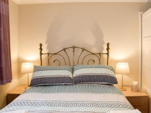 a bedroom with a bed with two lamps at Dougies Retreat in Pevensey