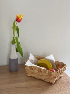 einen Obstkorb neben einer Vase mit einer Blume in der Unterkunft Klytti‘s Pension in Sendenhorst