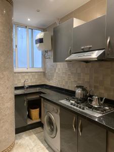 a kitchen with a stove and a washing machine at The Little Royal Mansour in Agadir