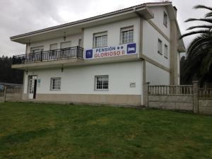 a white building with a sign on the side of it at Pensión Glorioso in Picaraña