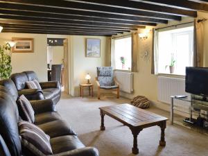 a living room with a couch and a coffee table at Well Cottage in Luxborough