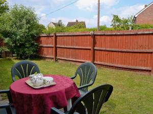 a table with a tea set on it in a backyard at Fairy Cottage in Old Newton