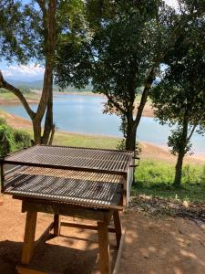 a picnic table with a view of a lake at Randeniya Hena in Teldeniya