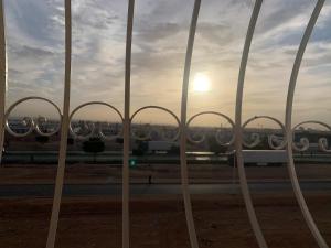 a view of the sunset through a metal fence at The Little Royal Mansour in Agadir