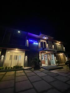 um edifício azul com um cartaz à noite em Christika Homestay em Labuan Bajo