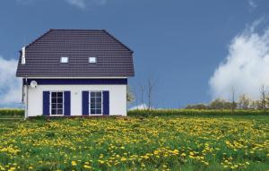 a small white house in a field of flowers at Ferienhaus 18 Altefähr in Altefähr