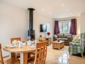 Lavender Cottage - Uk38682 في Oxhill: مطبخ وغرفة معيشة مع موقد خشبي