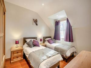 Lavender Cottage - Uk38682 في Oxhill: سريرين في غرفة مع ستائر أرجوانية