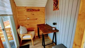 ケジョンにあるInversiones MM Gallardo SPA - Altos de Yaldad Cabañasの木製テーブルと椅子が備わる小さな客室です。