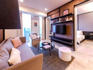 Una sala de estar con un sofá y un televisor. en Tropicana The Residences - KLCC VIEW Luxury Apartment Collections, en Kuala Lumpur