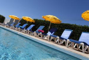 a row of chairs and umbrellas next to a swimming pool at Mira Parque in Albufeira