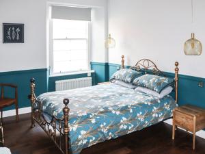 a bedroom with a bed with a blue and white bedspread at The Fishermans Loft in Cellardyke