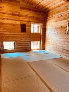 ein leeres Zimmer mit einem Fenster in einer Holzhütte in der Unterkunft 玄か~sizuka~ 